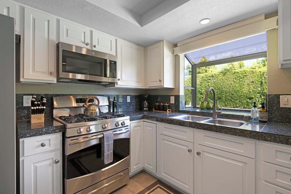 Fully equipped kitchen with gas range and garden views