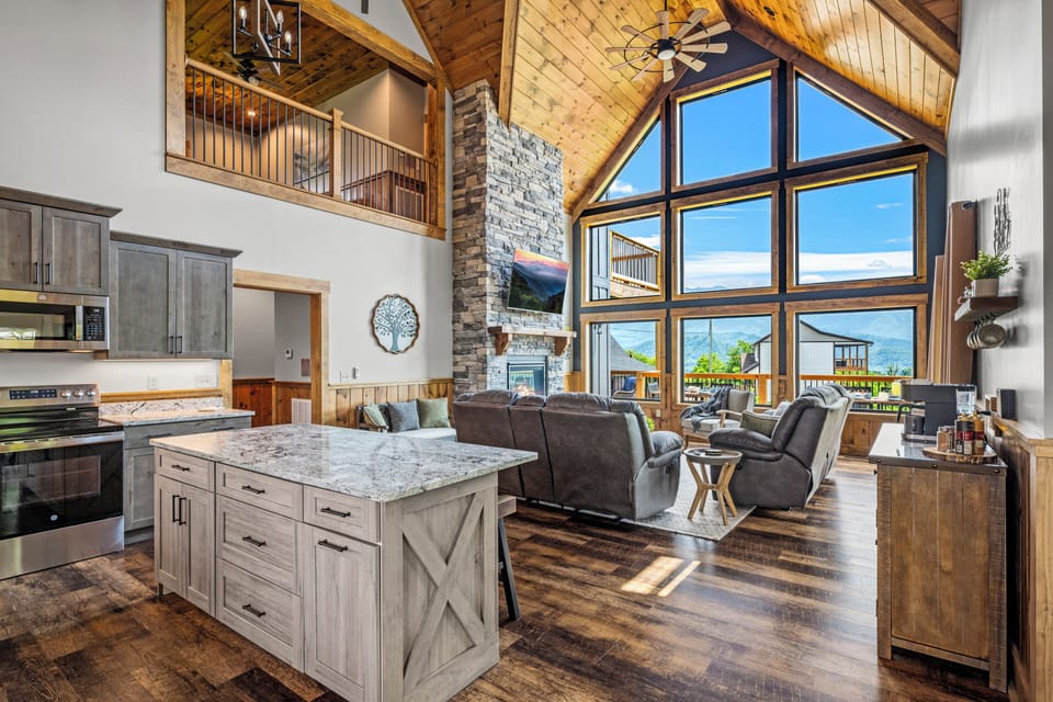 Open concept kitchen and living area with floor to ceiling windows.