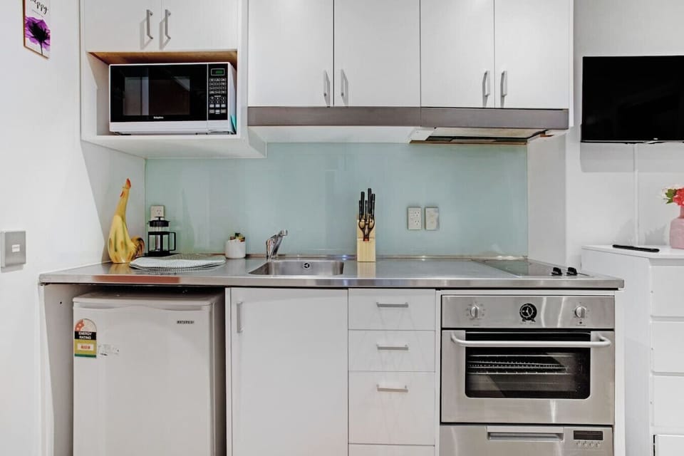 The kitchen has an oven, cooktop, mini fridge, microwave and dishwasher.