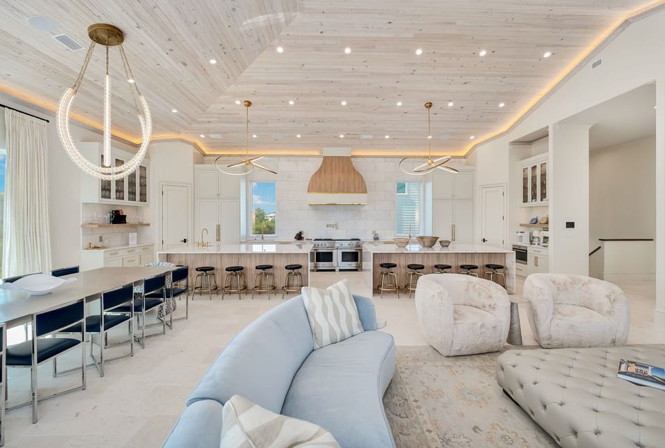 Gather in this stunning open-concept space where natural wood ceilings and designer lighting create a warm, inviting atmosphere. The spacious kitchen and cozy seating areas blend seamlessly for your perfect retreat.