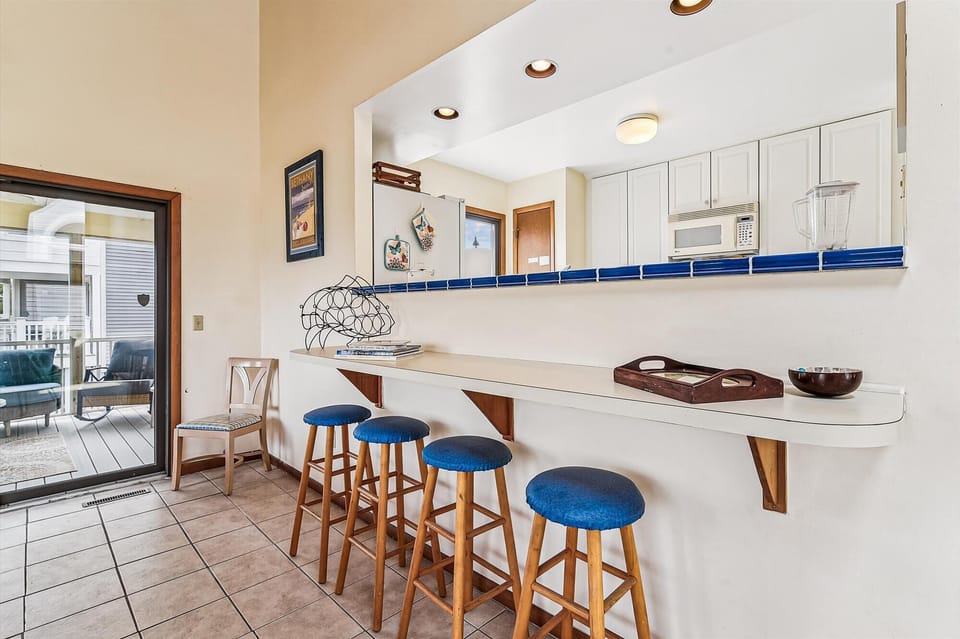 Pull up a seat at your private breakfast bar, where coastal charm meets convenience. With easy access to the deck, you'll love the bright, beachy vibe.