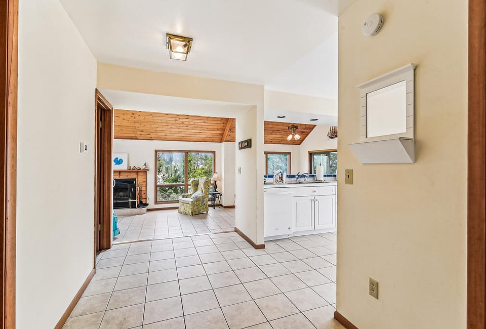 Step into your spacious, light-filled retreat with soaring ceilings and warm wood accents. The open layout flows seamlessly from kitchen to living areas, where natural light pours through large windows framing peaceful views.