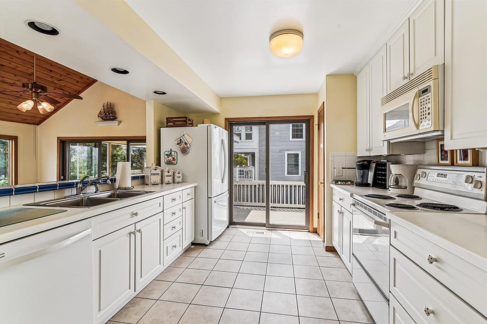 Prepare your favorite meals in this bright, fully-equipped kitchen with modern appliances, ample counter space, and direct access to your private deck for indoor-outdoor entertaining.