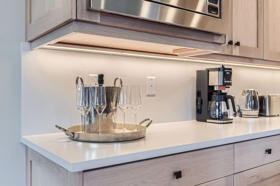 This luxury kitchen features a spacious center island with elegant seating, modern stainless steel appliances, and warm wood cabinetry. Stylish pendant lighting completes this inviting, gourmet space.