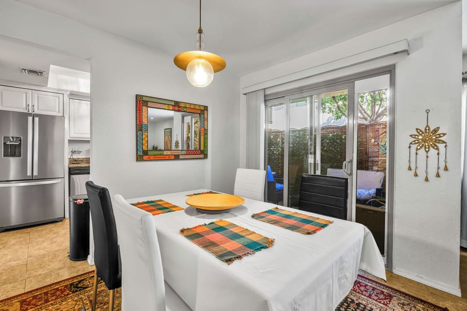 Dining area for four with patio access and open kitchen nearby