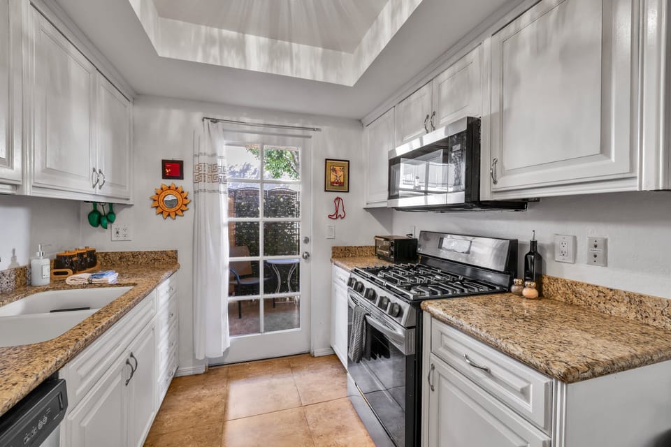 Fully equipped kitchen with gas range, microwave and granite counters