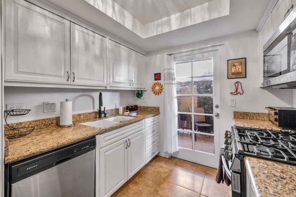 Bright kitchen with granite counters and patio access for easy dining