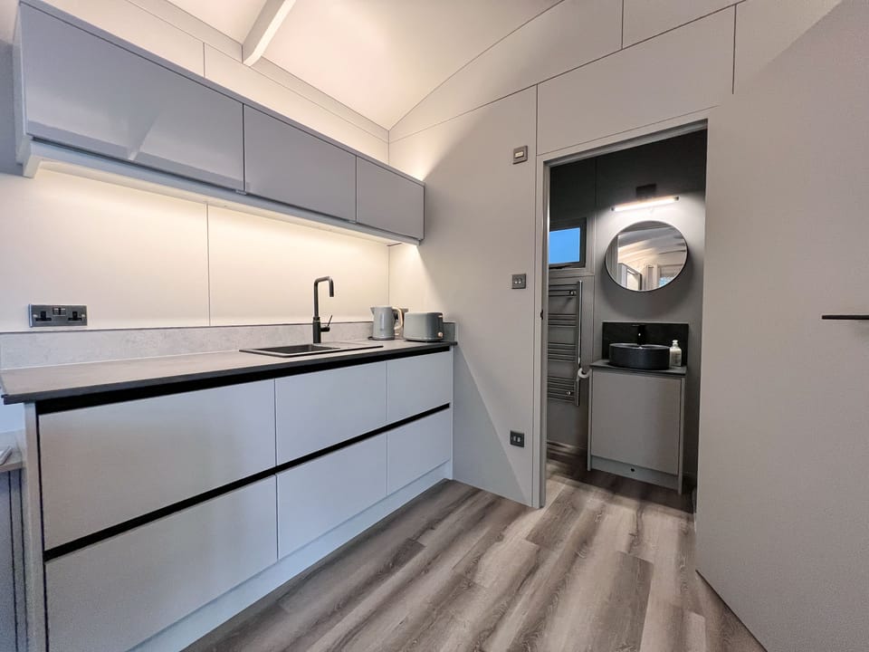 Molly (Marsham): Mini kitchen with a breakfast bar, microwave, twin hob, kettle, air fryer and fridge and the door to the shower room