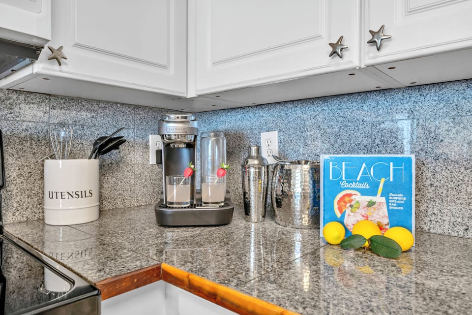 Your fully equipped kitchen corner features granite countertops, modern appliances, and thoughtful touches like fresh lemons and cocktail guides for memorable evenings.
