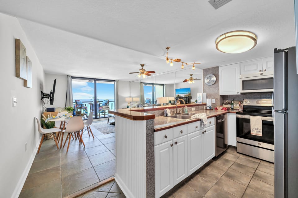 Your open-concept kitchen flows seamlessly into the living area, where you can cook while enjoying ocean views through floor-to-ceiling windows.