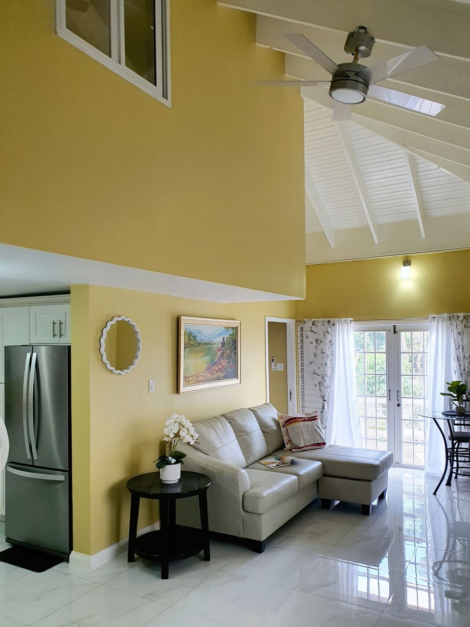 Bright open living space w/ sofa seating & balcony doors letting in natural light.