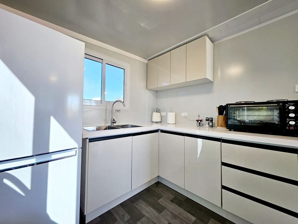 Kitchen with fridge, microwave, electric cooker and all the basics to cook a meal.