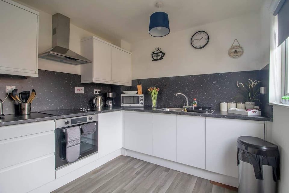 Full kitchen with complete appliances and essentials, ideal for convenient home cooking during your stay.