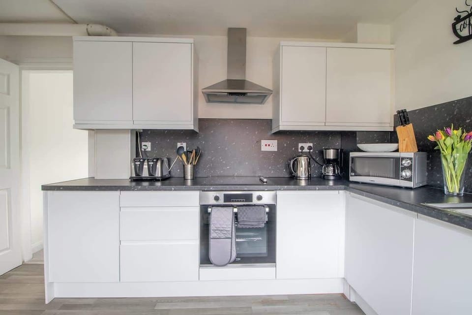 Full kitchen with complete appliances and essentials, ideal for convenient home cooking during your stay.