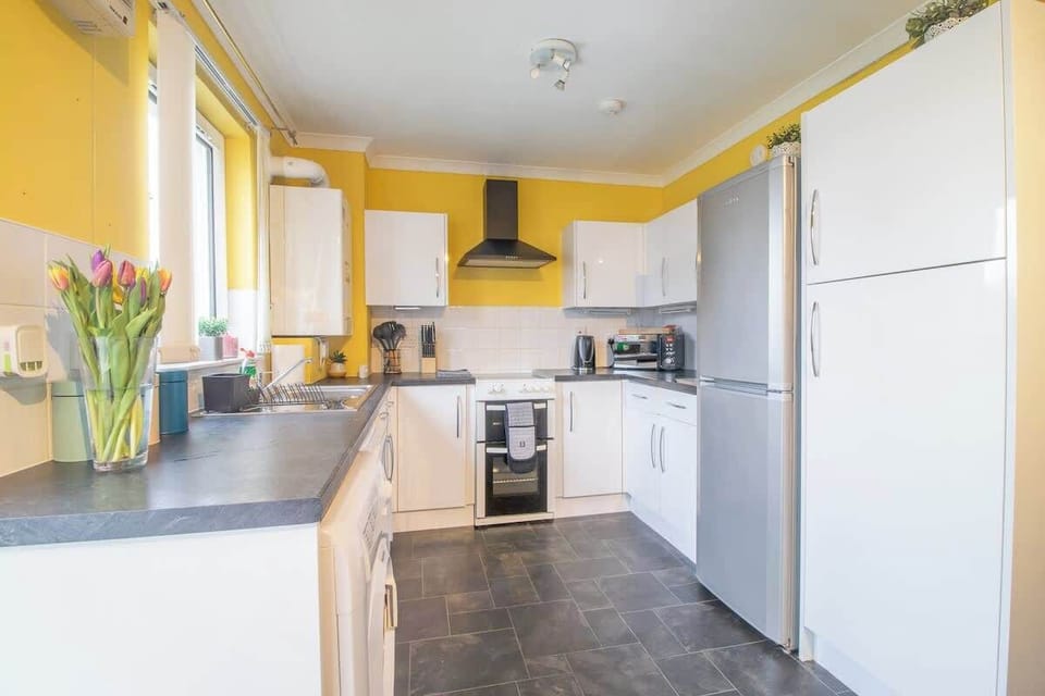 Fully equipped kitchen with modern appliances, cookware, and utensils for convenient home cooking during your stay.