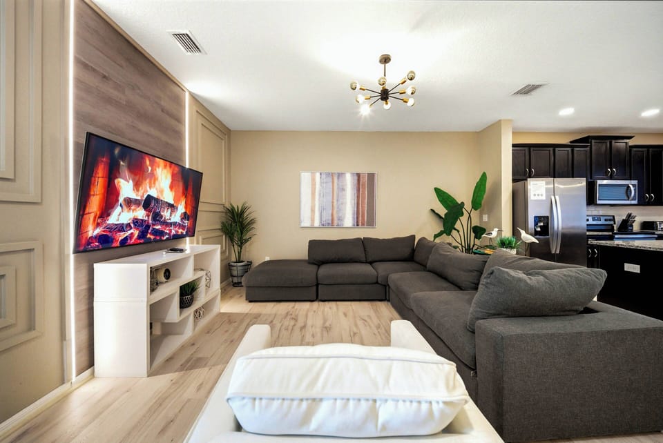 Relax in the spacious living area with a cozy sectional sofa, sleek hardwood floors, and a stylish modern fireplace, all designed to create a warm and inviting atmosphere for your comfort.