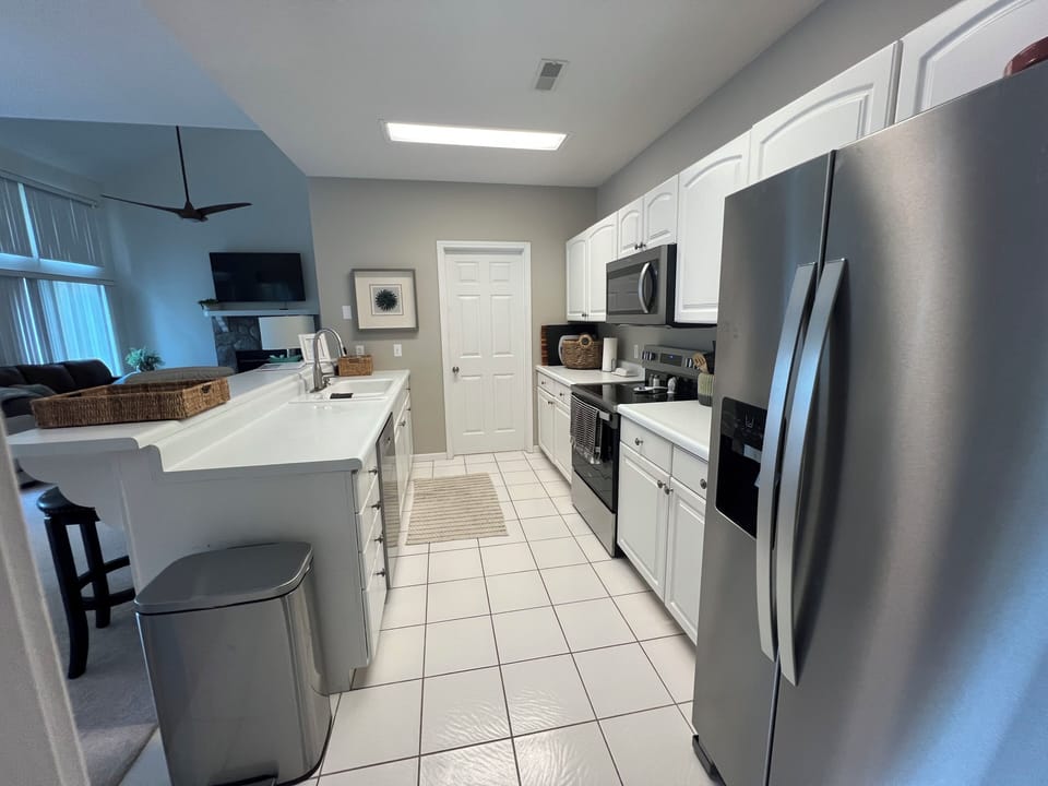 Kitchen adjoining dining and living rooms.  Brand new appliances Service for 12