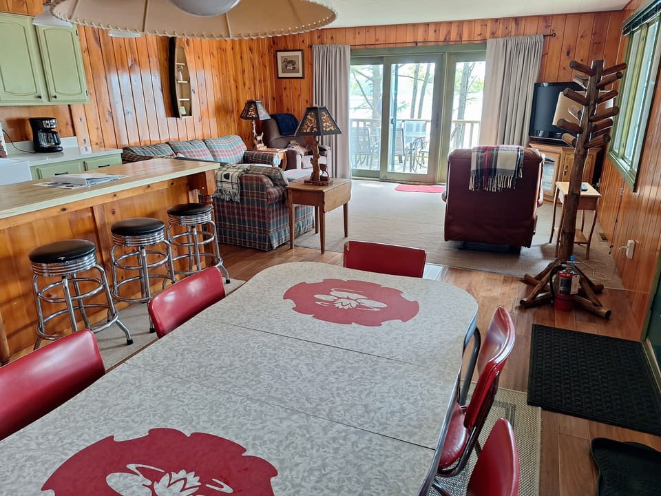 Open concept. Dining table with six chairs plus three stools at island.