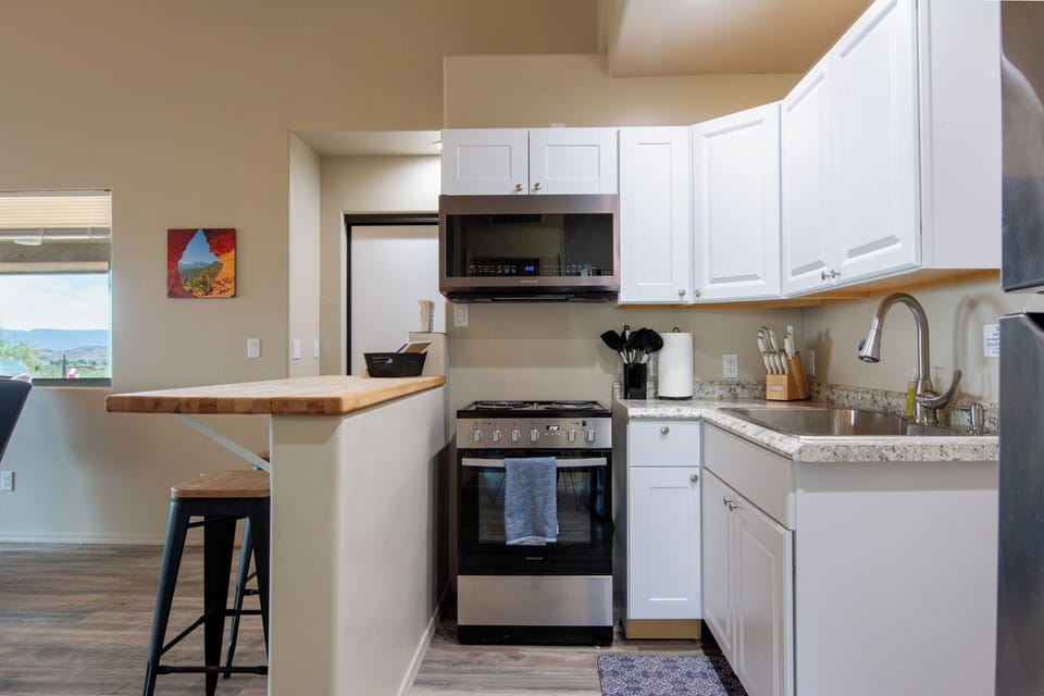 Kitchen with cooktop, oven, microwave, and refrigerator
