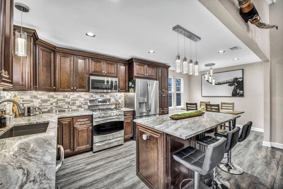 Recently remodeled, the kitchen features granite countertops, stainless steel appliances, modern cabinetry, and an open layout. Enjoy Austin-inspired decor while making your favorite meals in this fully-stocked kitchen.