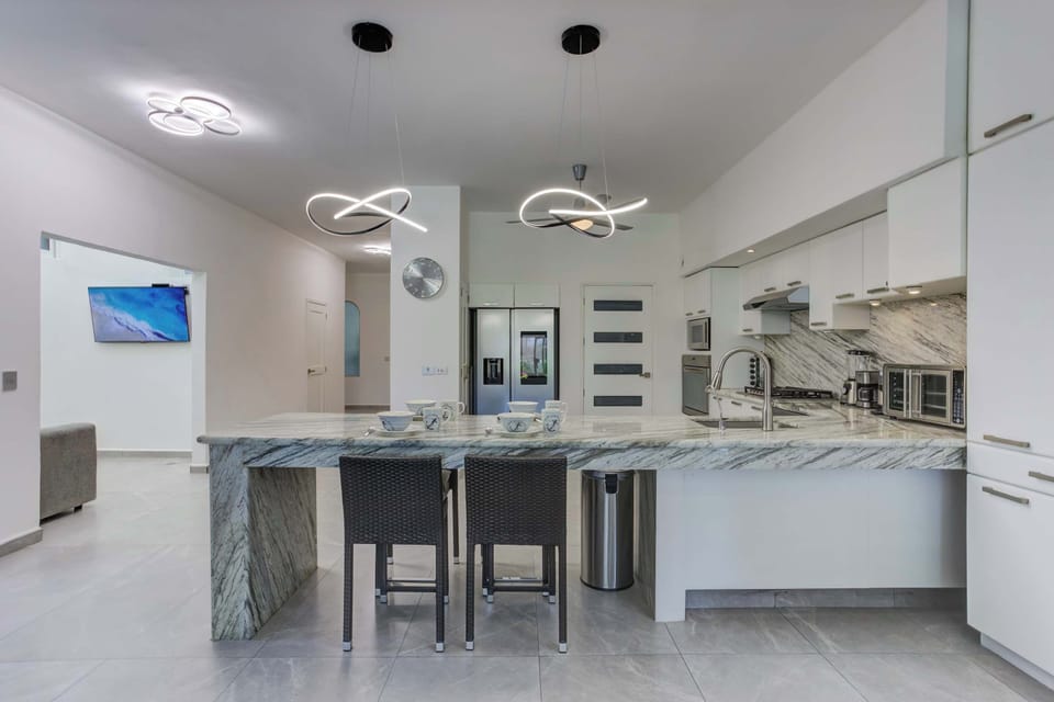 Full kitchen with breakfast area, with stove, refrigerator and cooking elements for your stay.