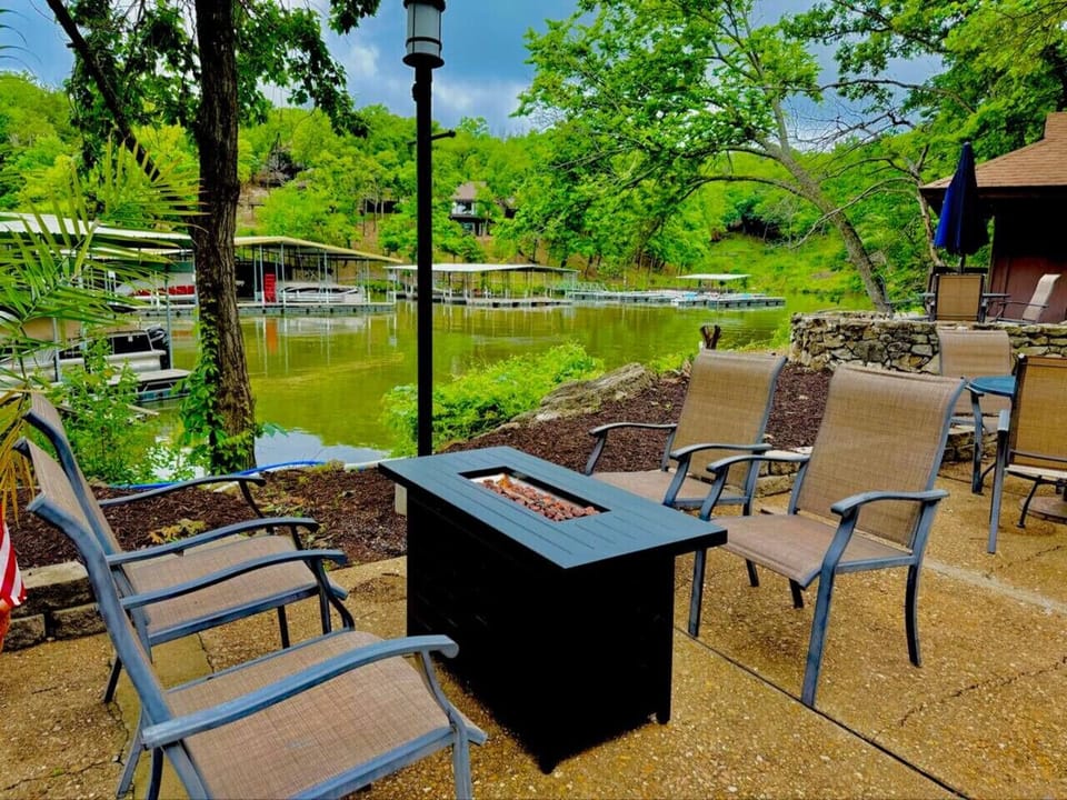 Firepit nestled by the dock, overlooking the tranquil lake, surrounded by lush greenery.