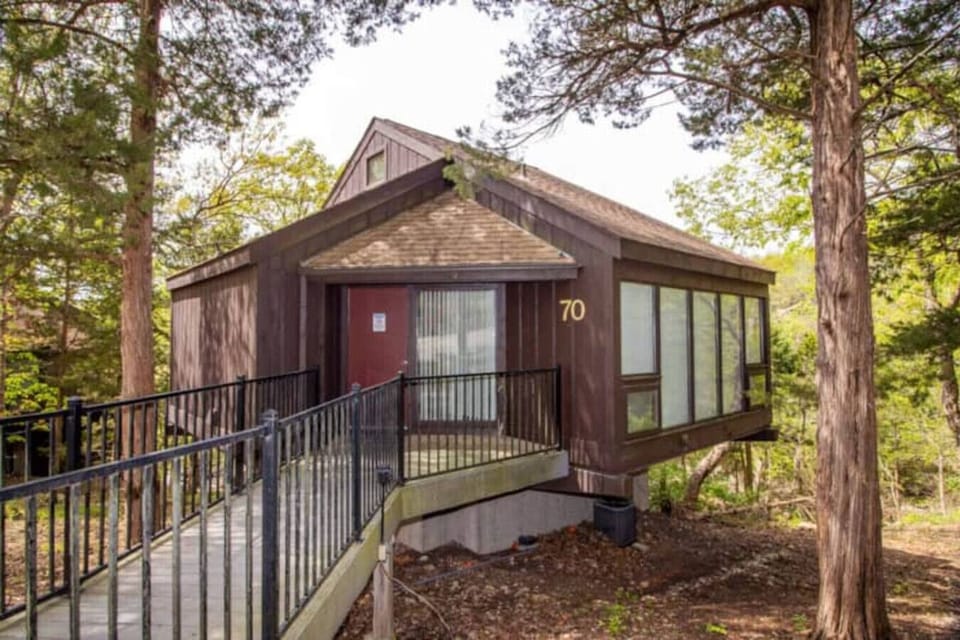 This modern elevated home offers a unique `treetop` living experience, blending seamlessly with the surrounding lush natural landscape. Multiple large windows allow for abundant natural light and scenic views, making this a bright and inviting retrea