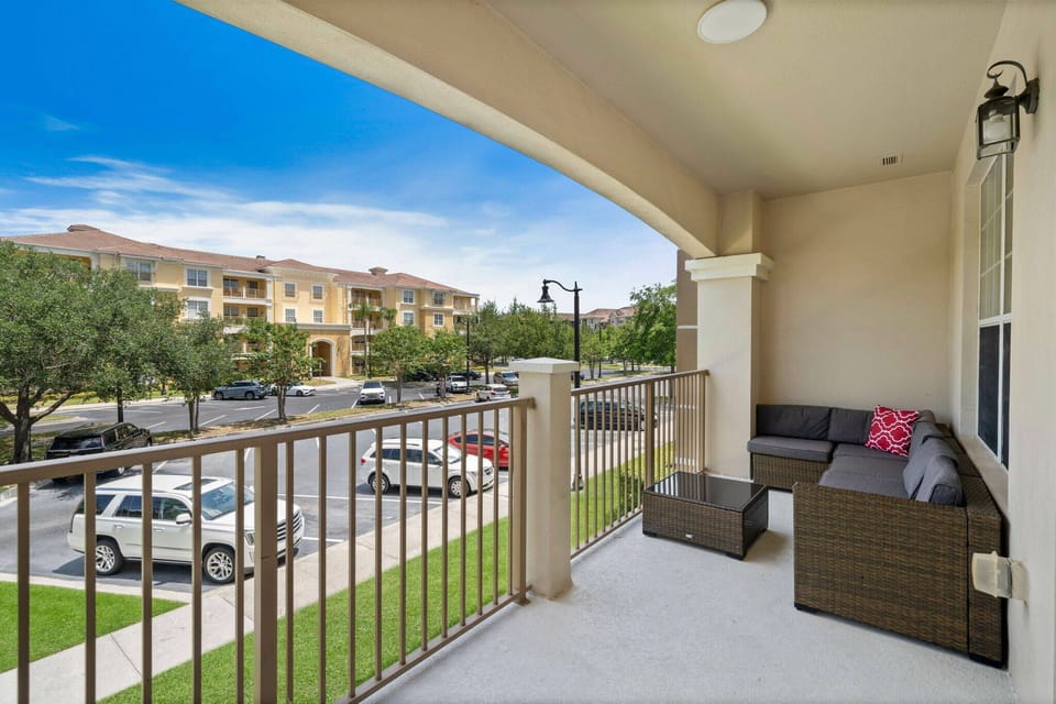 Step outside to your private balcony, where cozy seating invites you to relax. Enjoy the fresh air under the blue sky, with a colorful accent pillow adding a cheerful touch to your moments of tranquility.