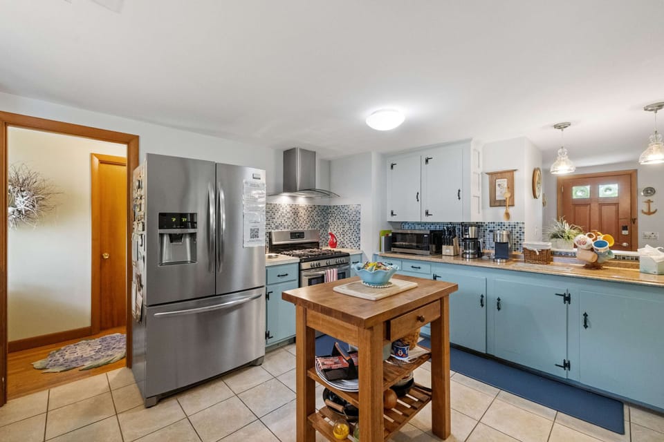 The open layout makes cooking a joy—complete with stainless steel appliances, a spacious fridge, and all the cookware and gadgets you need to dine in comfortably.