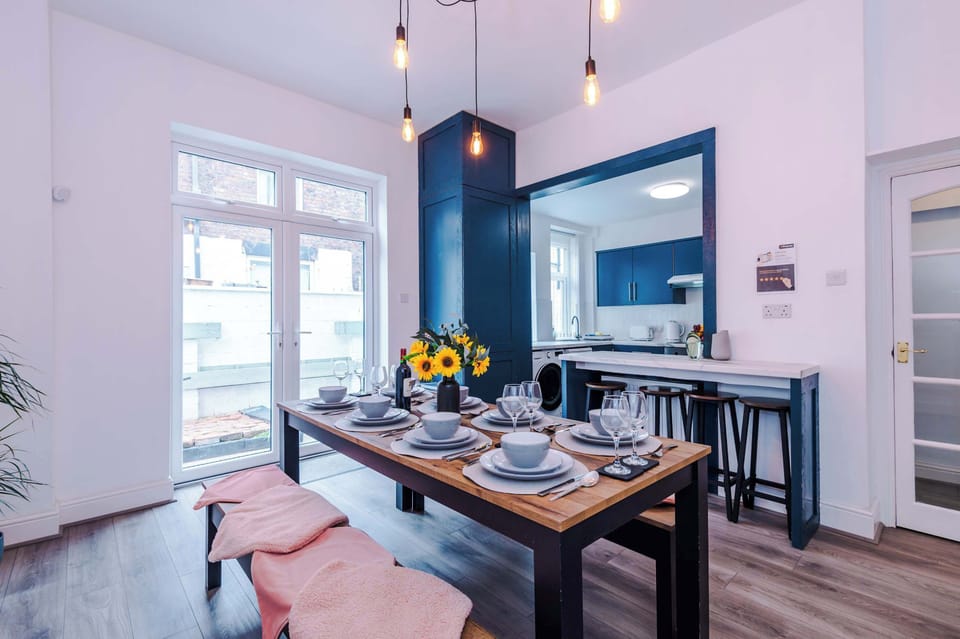 A stylish dining area designed for comfort and connection. The elegant table setting, warm pendant lights, and large window create a bright space perfect for breakfast, dinner, or planning the day ahead.