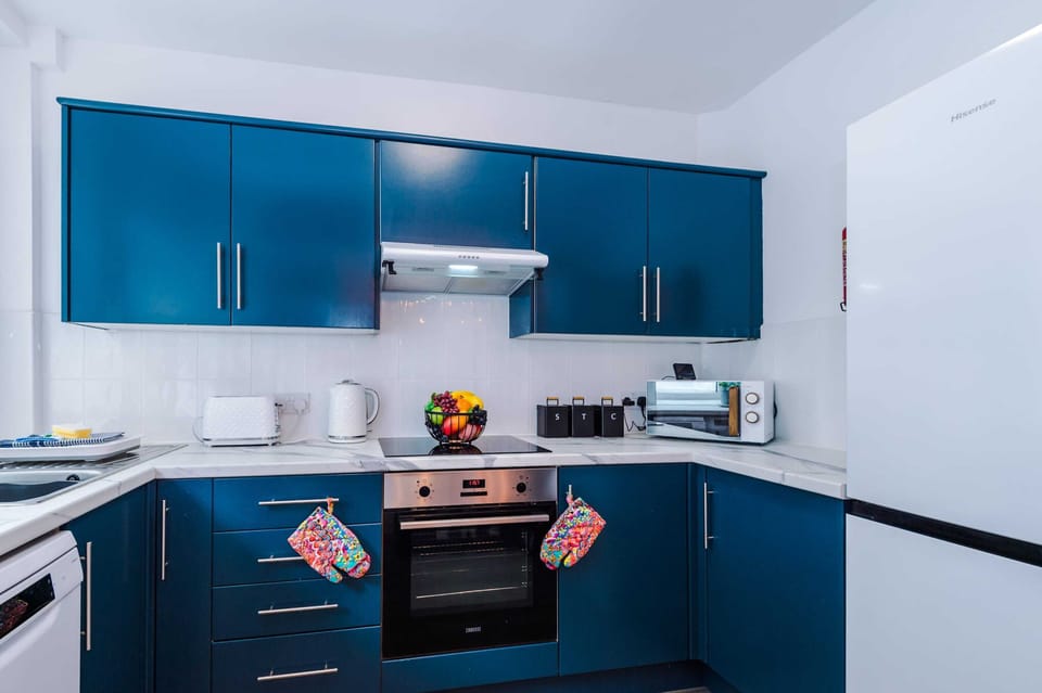Bright, contemporary design defines this kitchen and dining area. Sleek cabinetry, a striking light fixture, and pops of color create a welcoming atmosphere. Ideal for shared meals, cozy conversations, and stylish entertaining in comfort