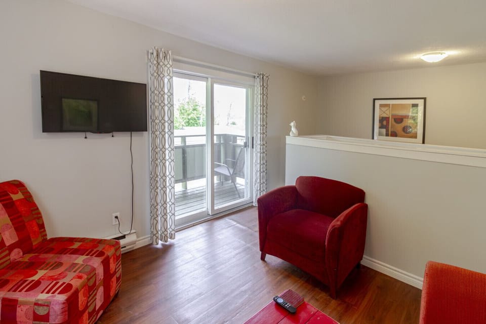 Living room with TV and balcony on upper level
