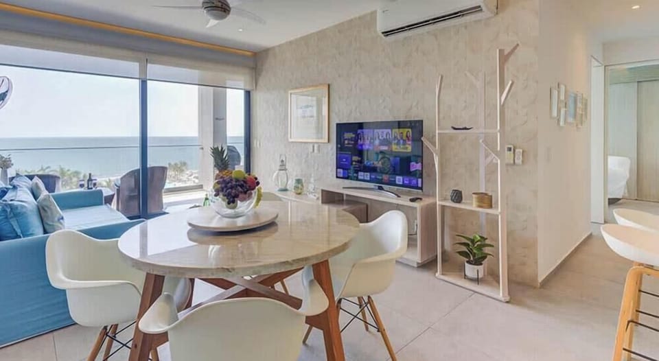 Dining area w/ table for four set beside sliding doors leading to the balcony