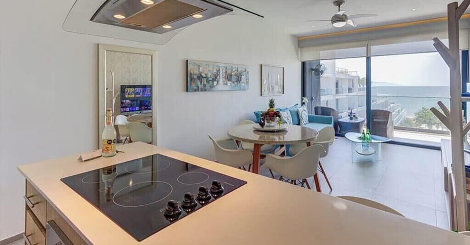 Modern kitchen island w/ cooktop & stainless hood, open to the dining space