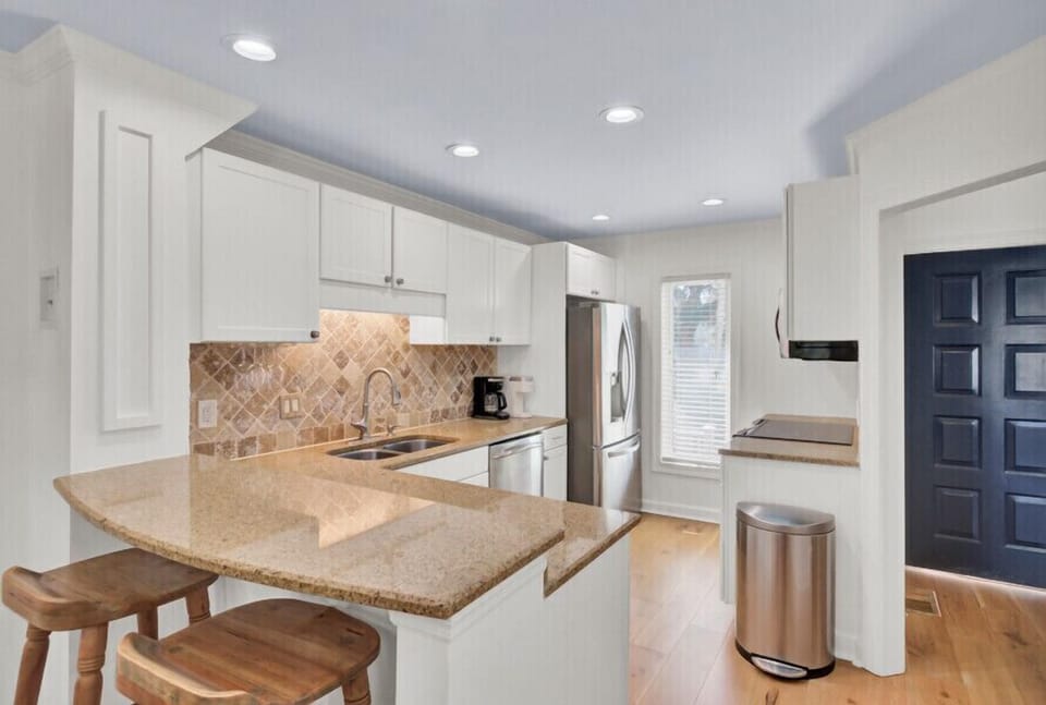 Prepare your favorite meals in this bright, fully-equipped kitchen with modern appliances, granite counters, and a handy breakfast bar for morning coffee.