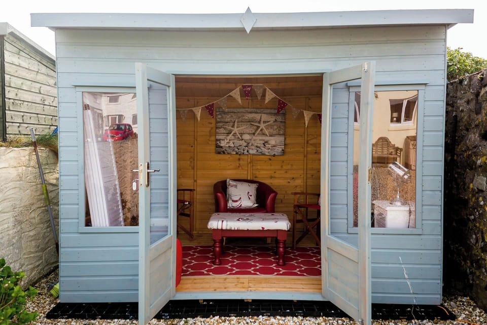 summer house with table and chairs in the garden
