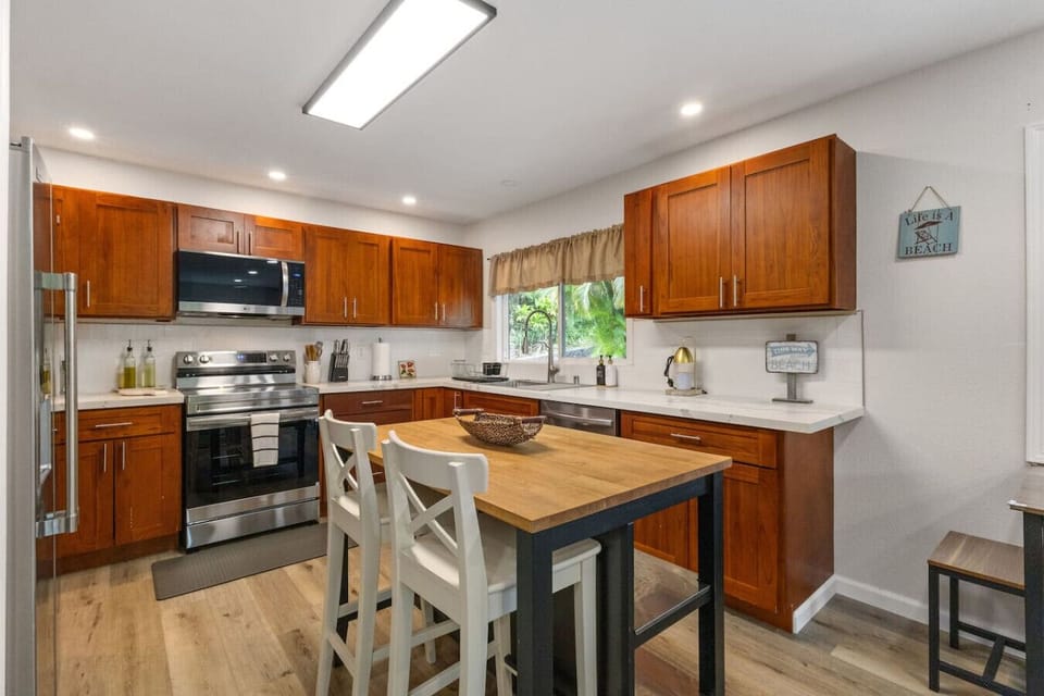 Bright, modern kitchen with warm wood cabinetry and a cozy island—perfect for cooking and gathering.