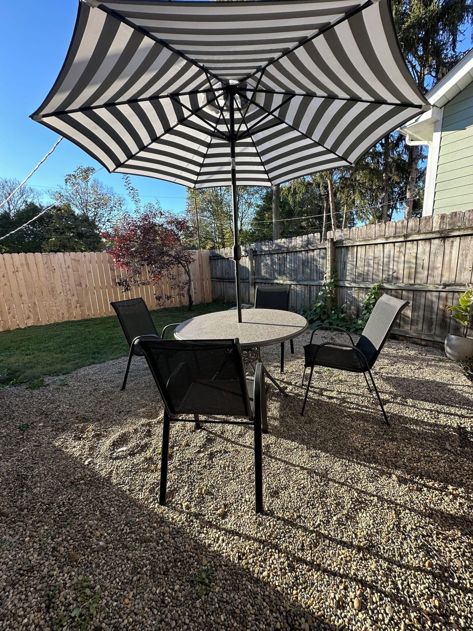 Private fenced backyard with patio seating and fire pit.
