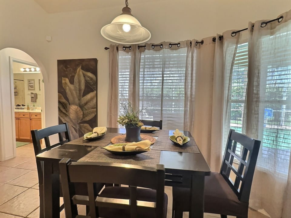 Dining room from alternate angle with natural light from the windows highlighting the table and chairs