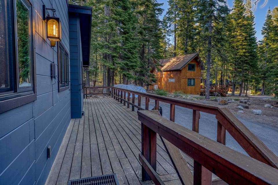 Exterior: Main entry deck with railing, forest view, and on-site driveway parking