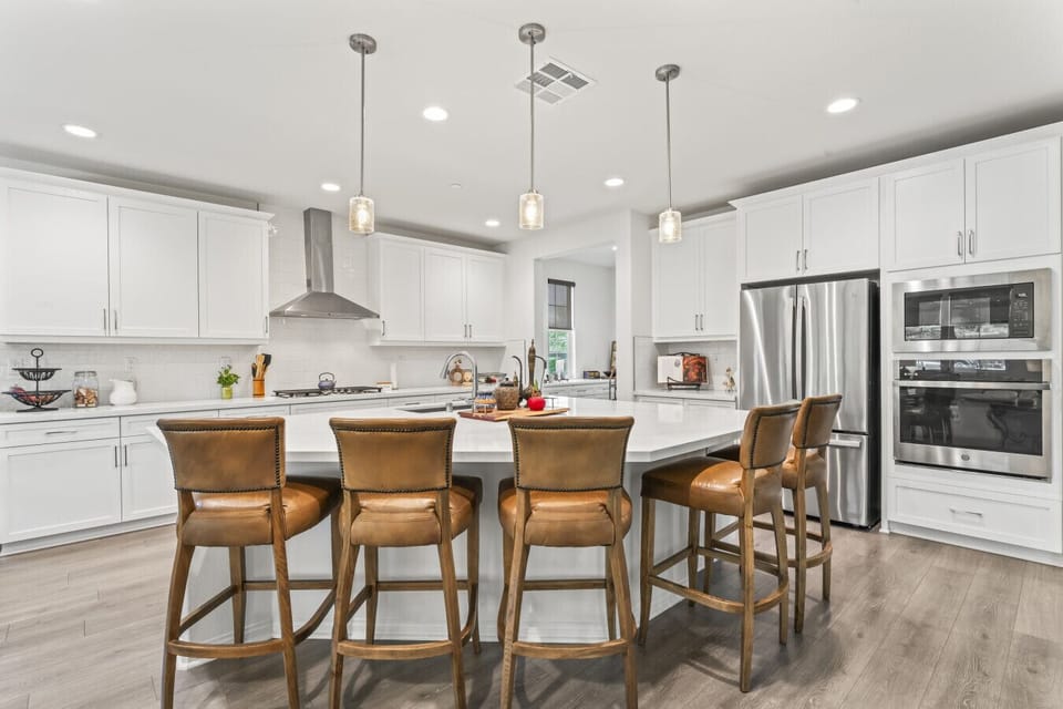 Open-concept kitchen w/ bar seating, flowing seamlessly into the living area