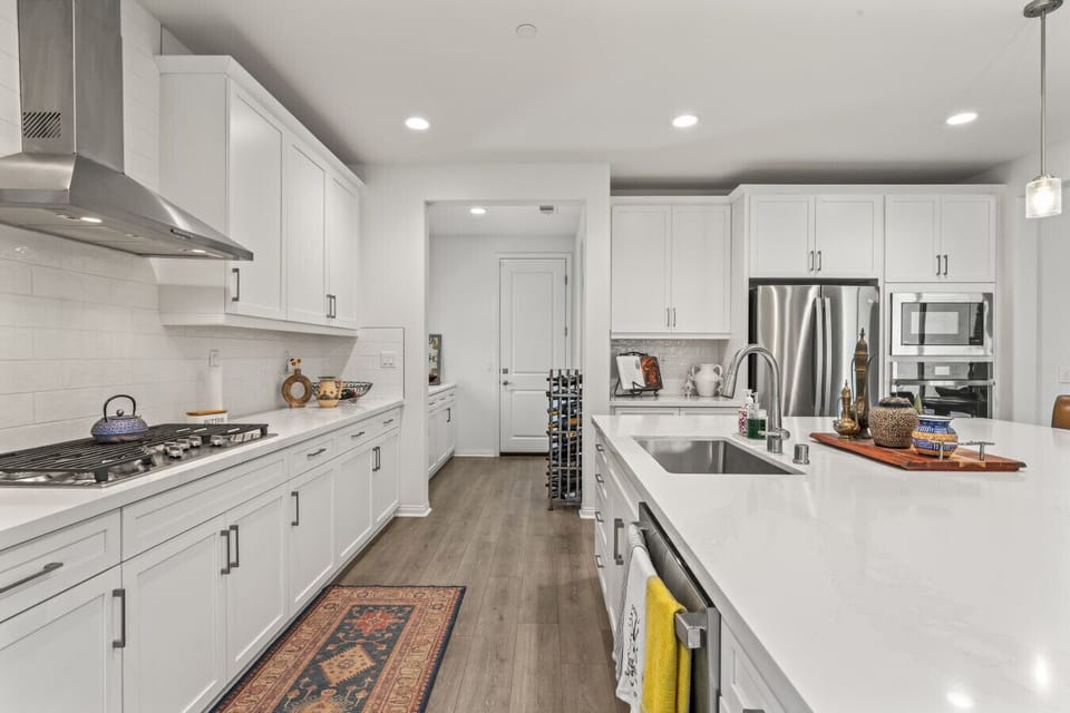 Sleek galley kitchen w/ long counters, stainless appliances & ample storage