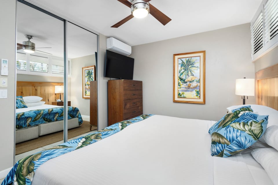 Sink into your comfortable bed beneath a gentle ceiling fan, with tropical decor and modern amenities creating your perfect island retreat.