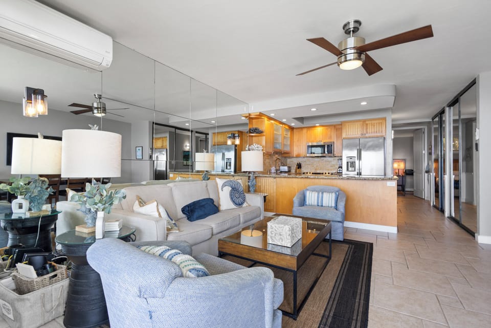 Relax in your bright, open living area where coastal style meets comfort—ceiling fans keep things breezy while you unwind on plush seating.