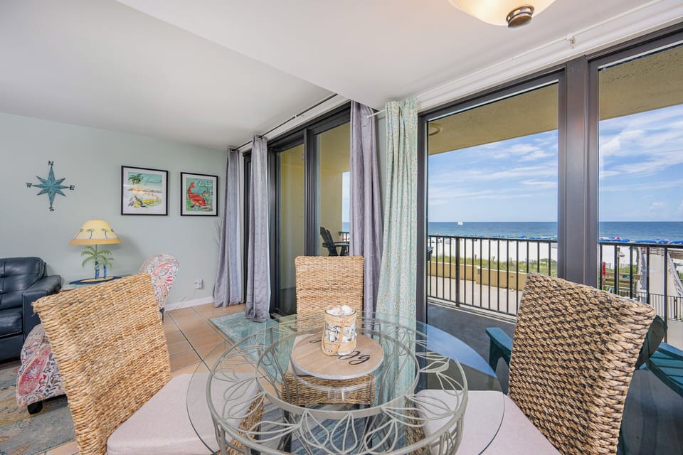 Bright and inviting dining area with a glass table and chairs with a breathtaking view of the tranquil shoreline