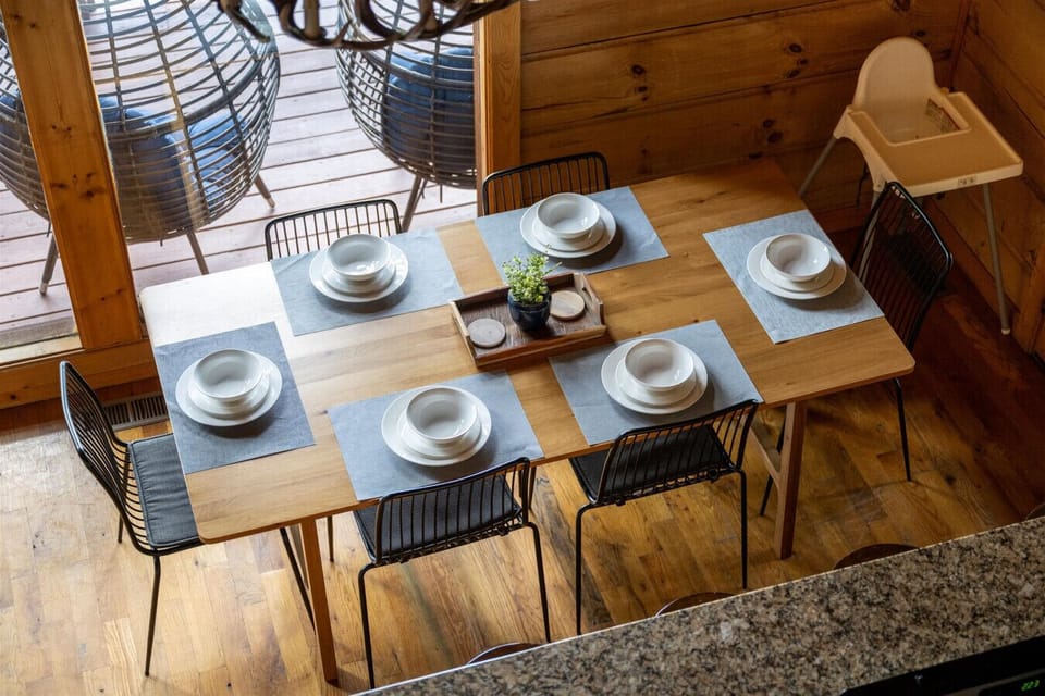 Gather around the table for shared meals and easy conversation, with natural light and deck access just steps away.