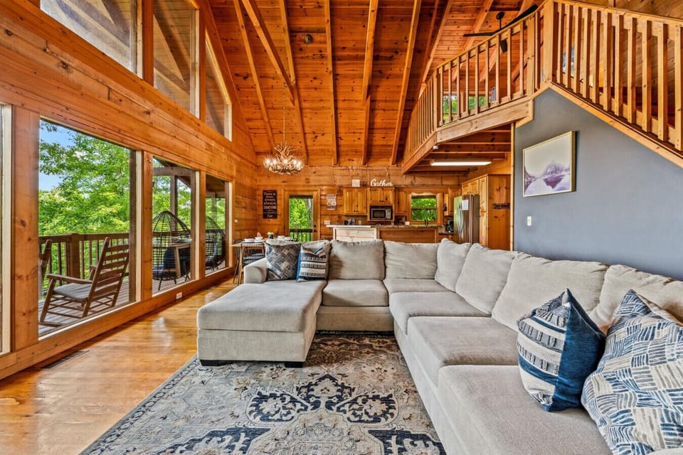 Soaring ceilings, warm wood tones, and a spacious sectional invite everyone to gather—whether it’s movie night, morning coffee, or planning the next day’s adventure.