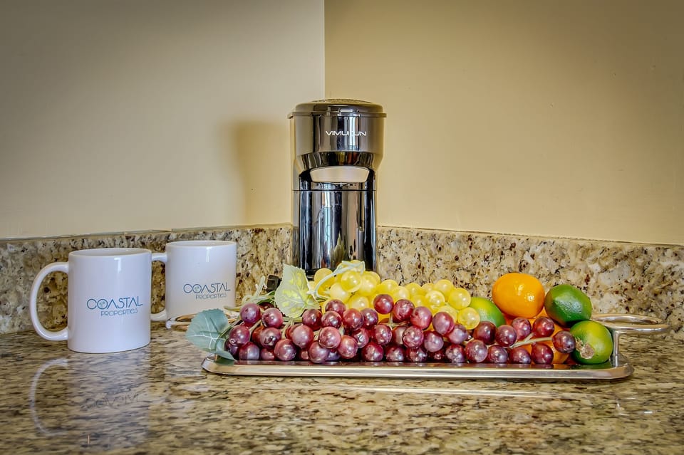 The kitchen area exudes coastal charm, complementing the suite's overall aesthetic for a truly immersive oceanfront living experience.