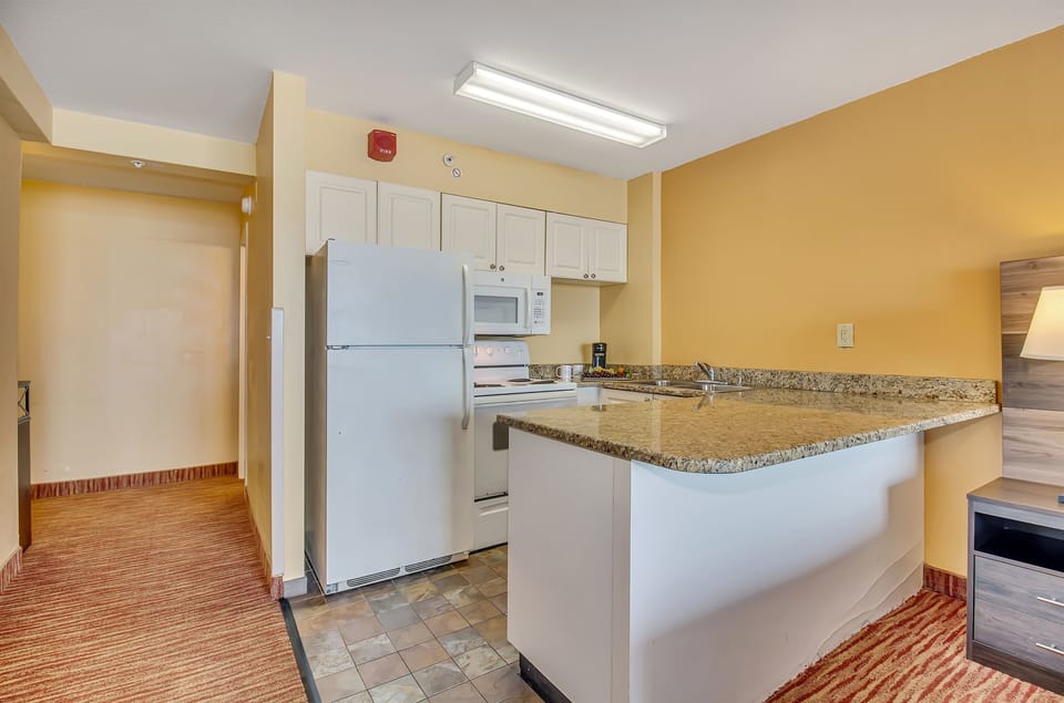 The kitchen area exudes coastal charm, complementing the suite's overall aesthetic for a truly immersive oceanfront living experience.