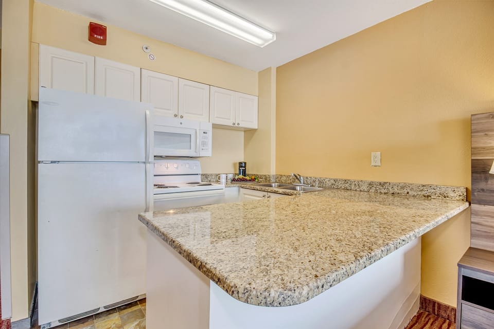 The kitchen area exudes coastal charm, complementing the suite's overall aesthetic for a truly immersive oceanfront living experience.